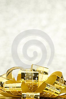 Close up Golden present box with big bow at bokeh white blur background, Leave space on top to adding your content photo